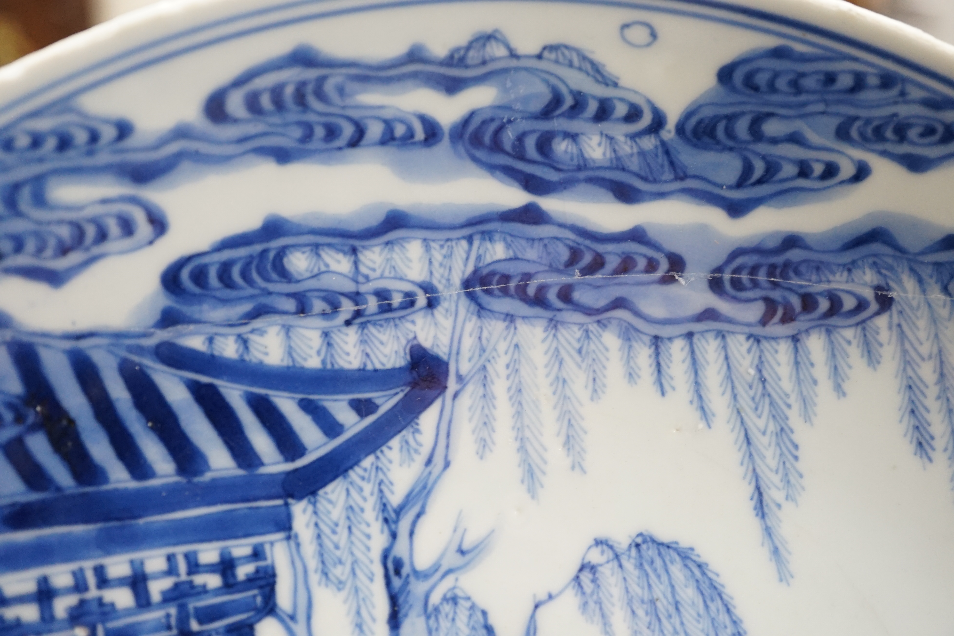 A Chinese blue and white dish, Kangxi period, broken and messily reglued